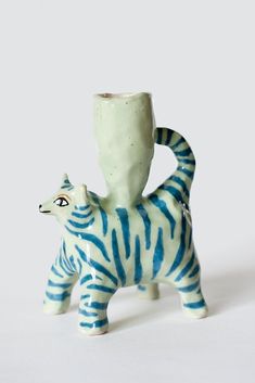 a blue and white ceramic animal figurine with a cup on it's back