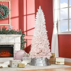 a white christmas tree sitting next to a fireplace