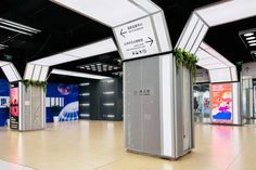 an empty shopping mall with multiple displays on the walls and floor, along with plants growing out of them