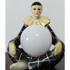 a statue sitting on top of a table holding a white ball