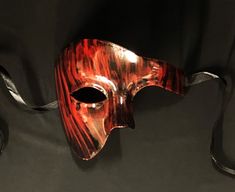 This Phantom mask is hand painted in a sold black then brushed red to give an abstract look. Mask is fully sealed and has a nice gloss look, Great for any Masquerade event or mask costume party! Size 6.5"W x 5.5"H. Color red and black.