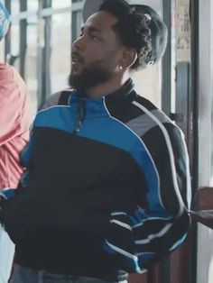 a man standing in front of a bus with his back to the camera and wearing a hat