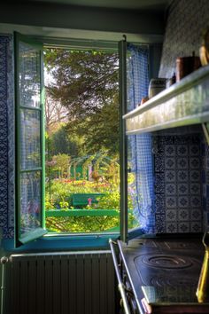 a green bench sitting in the middle of a kitchen next to a window with blue curtains