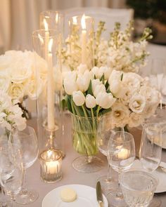 the table is set with white flowers and candles