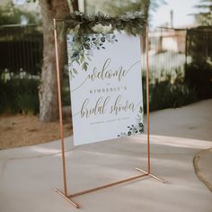 a welcome sign with greenery on it