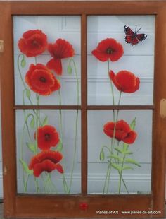 an old window with red flowers and a butterfly painted on the glass in front of it