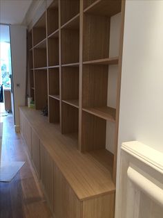 an empty room with wooden shelves on the wall and wood flooring in front of it