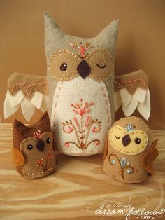 an owl and two owls are sitting next to each other on a wooden table with gold sequins