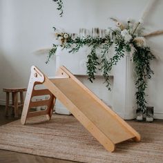 a child's wooden slide next to a fireplace