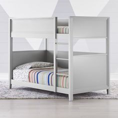 a white bunk bed sitting on top of a carpeted floor next to a wall