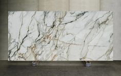 a large white marble slab sitting in a room next to two metal boxes on the floor