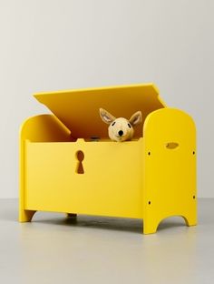 a yellow toy storage box with a stuffed animal in it