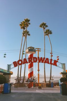 there is a large sign that says boardwalk on the front of it and palm trees behind it