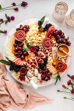 a white plate topped with grapes, cheese and crackers