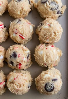 chocolate chip cookies and candy canes are arranged on a baking sheet, ready to be eaten