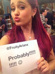 a woman with red hair holding up a sign that says, fruity ariaa probably