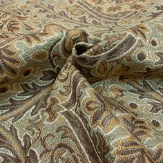 a close up view of a paisley print fabric with brown and green colors on it