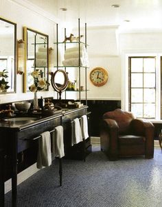 a bathroom with a chair, mirror and sink in it's centerpieces