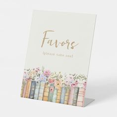 a card with flowers and books on it that says favers please take one in gold lettering