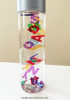 a water bottle filled with colorful letters on top of a table