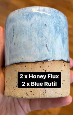 a hand holding a blue and brown pot with the words 2 x honey flux on it