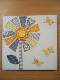 an art piece with yellow buttons and butterflies on it