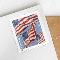 a postage stamp with the american flag on it and an envelope in front of it