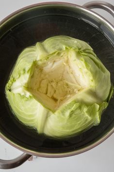 an open head of lettuce in a saucepan on the stove top, ready to be cooked