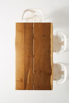 a wooden table with two white cups on it's top and one in the middle