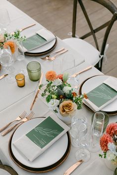 a table set with place settings and flowers