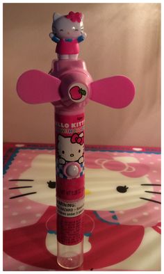 a pink hello kitty toothbrush holder sitting on top of a white and pink table