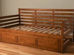 a wooden bed frame with two drawers on the bottom, and a window in the background