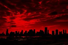 a red sky with clouds over a city