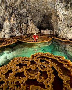 a man standing in the middle of a cave filled with water