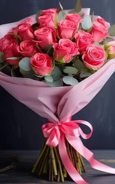 a bouquet of pink roses with green leaves