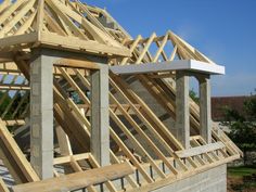 a house being built with wooden framing on the roof