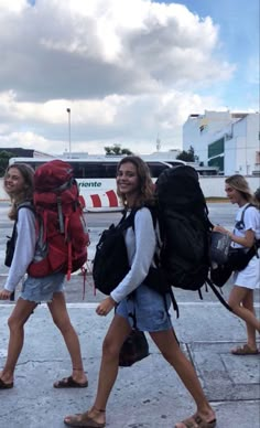 two women walking down the street with backpacks on