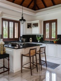 a kitchen with two bar stools and an island in front of the stove top