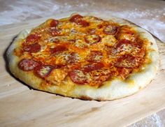 a pizza sitting on top of a wooden cutting board