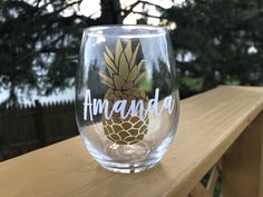 a clear wine glass with a pineapple on the bottom and words amando written in white