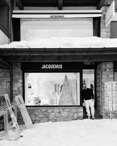 a man standing in front of a store with snow on the ground