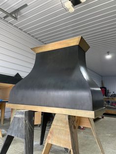 a large black piece of wood sitting on top of a wooden stand in a garage