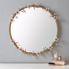 a mirror that is sitting on top of a table next to a brush and toothbrush