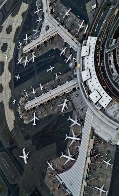 an aerial view of several airplanes parked at the airport gates and parking lots in front of them