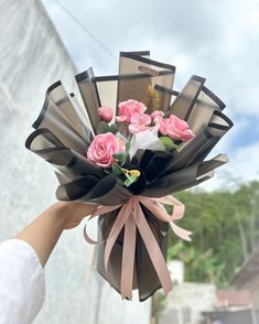 a person holding a bouquet of flowers in their hand