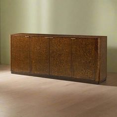 a wooden cabinet sitting on top of a hard wood floor next to a green wall