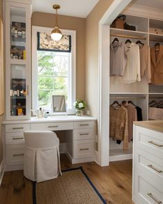 a white desk and chair in a room with lots of closet space on the walls