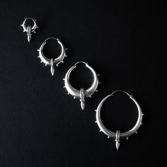 Handcrafted with precision, these chunky hoop earrings stand as a signature piece from Pushkar, Rajasthan. The elegantly rebellious design, adorned with dots, twisted wire, and spikes, pays homage to the timeless artistry of ancient Rajasthan. These hoops transcend mere accessories, embodying a unique blend of boldness and craftsmanship, making a powerful statement wherever they go. Design: Rajasthan Heritage Material: 925 Silver Sizes XS: 2 cm x 3 cm [6,5 g] S: 3,5 cm x 4,5 cm [13 g] M: 4,5 cm x 5,5 cm [22 g] L: 5,5 cm x 6,5 cm [23 g] Pushkar Rajasthan, Gold Cartilage Earrings, Earrings Stand, Conch Jewelry, Monogram Earrings, Small Gold Hoop Earrings, Simple Hoop Earrings, Initial Earrings, Chunky Hoop Earrings