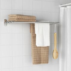 a towel rack with two towels hanging on it and a bamboo brush next to it