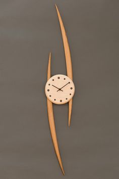 a clock made out of wooden sticks with dots on the face and hands is floating in water